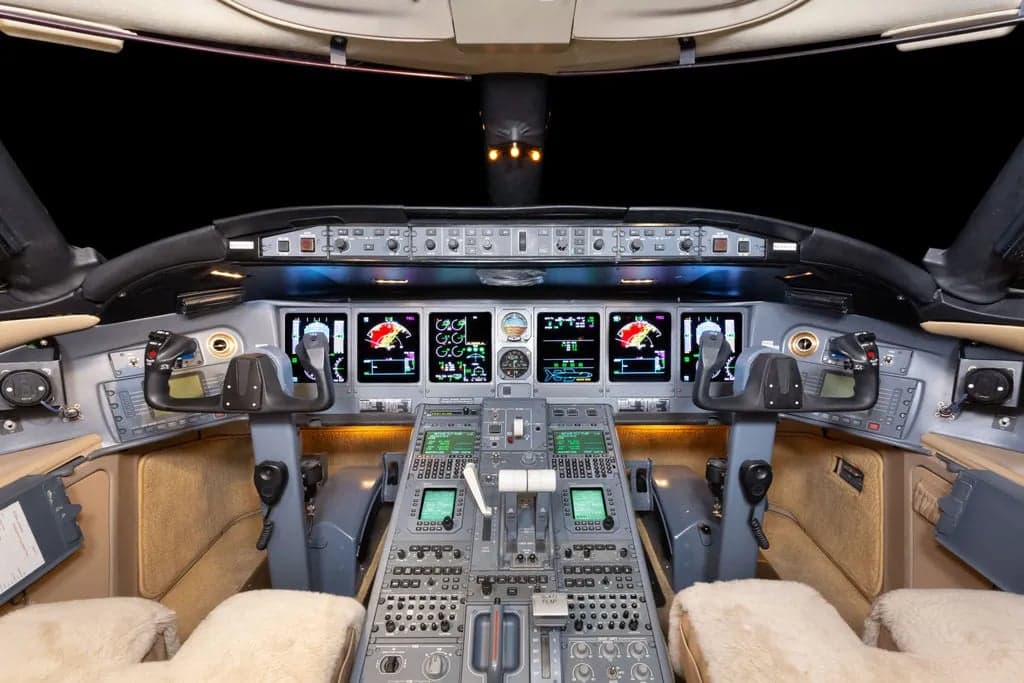 The cockpit of a Bombardier Global Express aircraft, showing the instrument panel and controls.