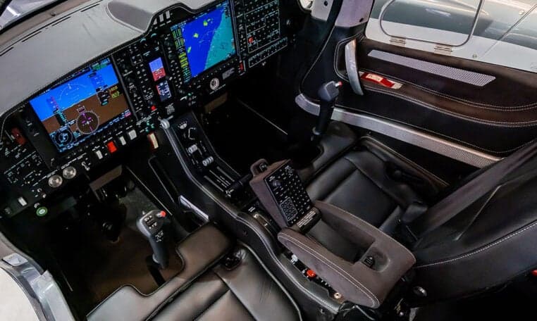 View of the Diamond DA62 cockpit from the side, showing the instrument panel and seats.