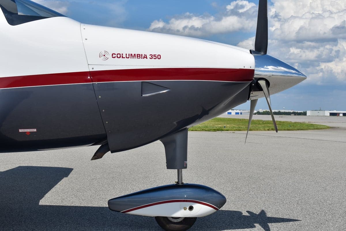 Columbia 350 aircraft with doors open on the tarmac.