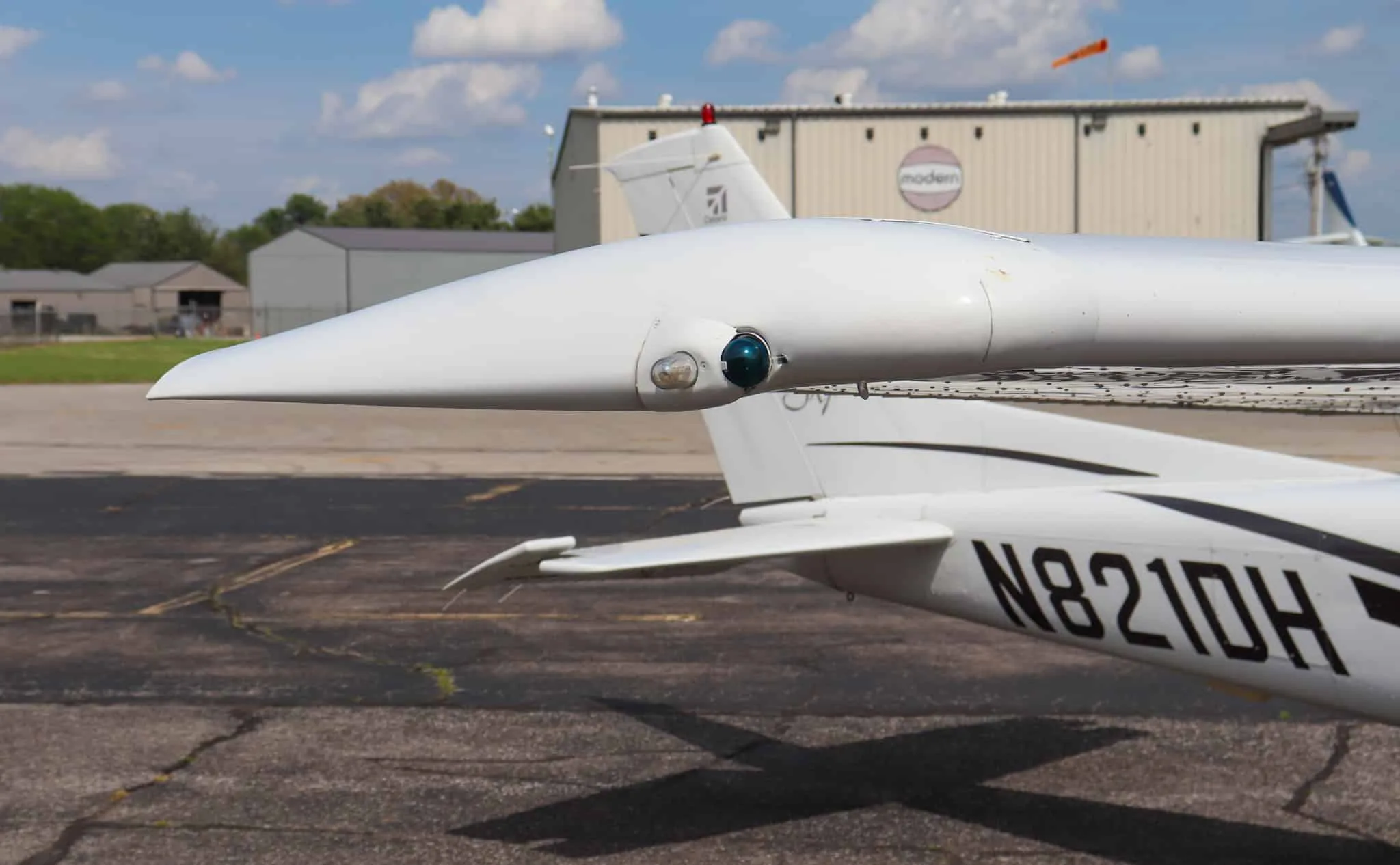 A close-up of the right wingtip of the Cessna Skylane N821DH, showing the navigation light and registration.