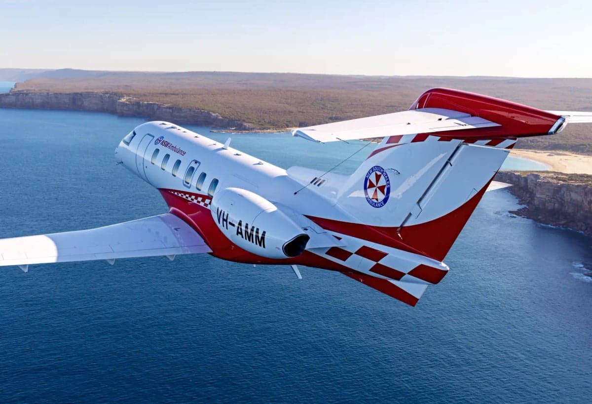 A Pilatus PC-24 aircraft in flight over the ocean.
