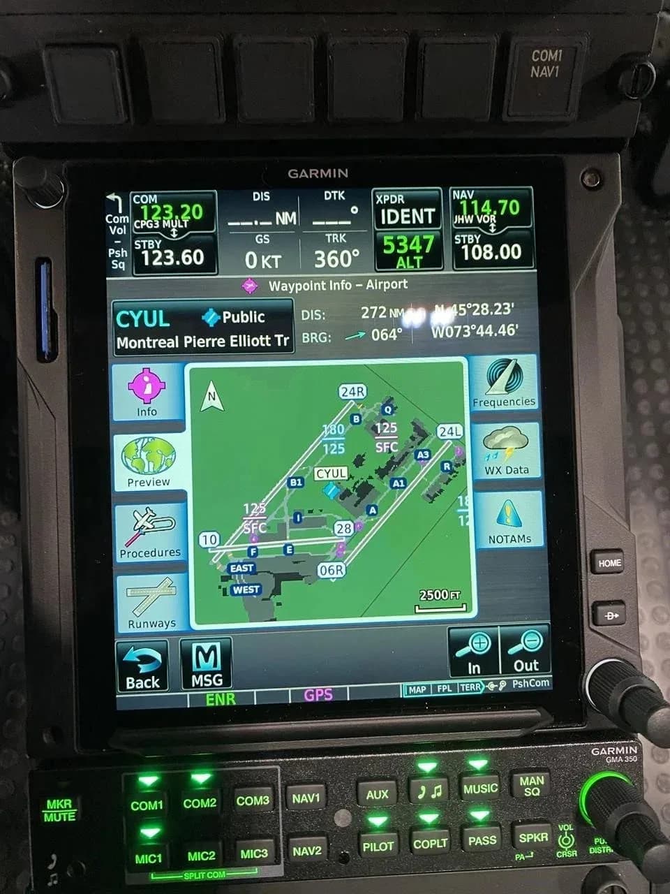 A close-up of the helicopter's cockpit display showing a navigation map with an airport diagram and flight information.