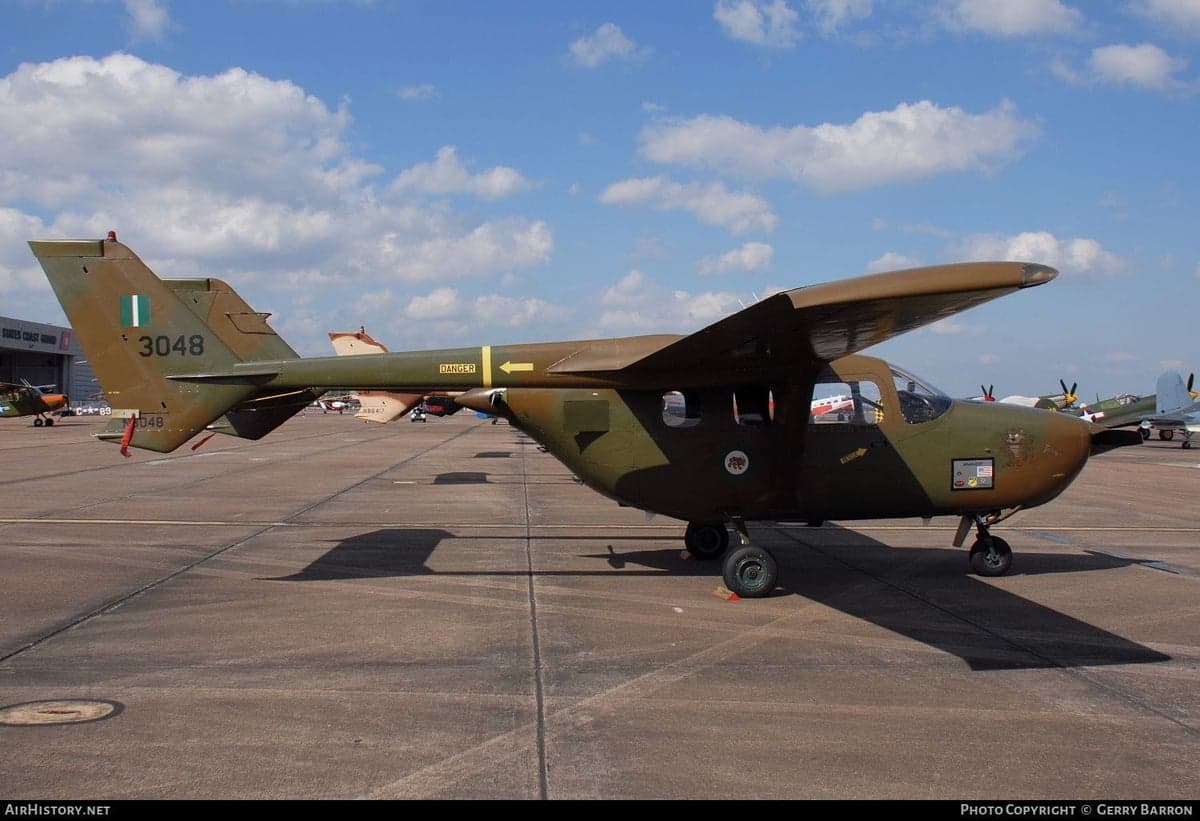A military-style Cessna O-1 Bird Dog aircraft on the tarmac.