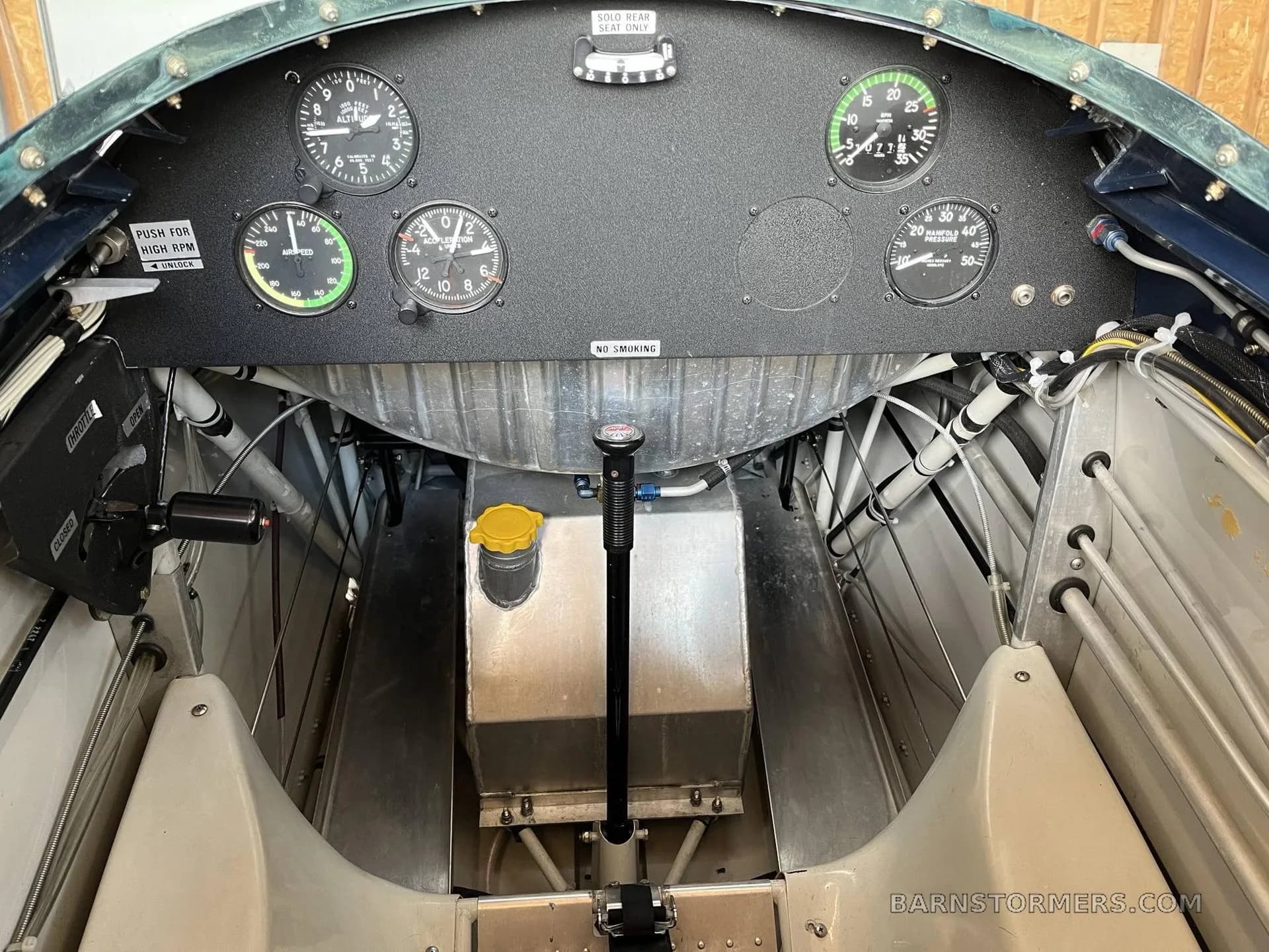 The interior of an aircraft showing the rear instrument panel, structural elements, and a fuel tank.