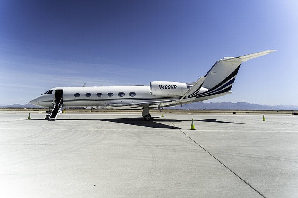 A Gulfstream jet with an open door and airstair on the tarmac.
