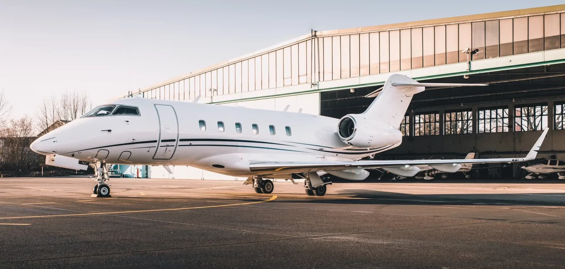 A Challenger aircraft parked on the tarmac in front of a hangar.