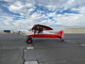 A red and white Cubcrafters FX-3 aircraft on the tarmac.