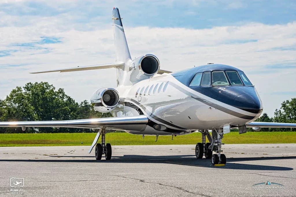 A Dassault Falcon 900EX business jet, registration N86TN, parked on an airfield, viewed from the front-right.