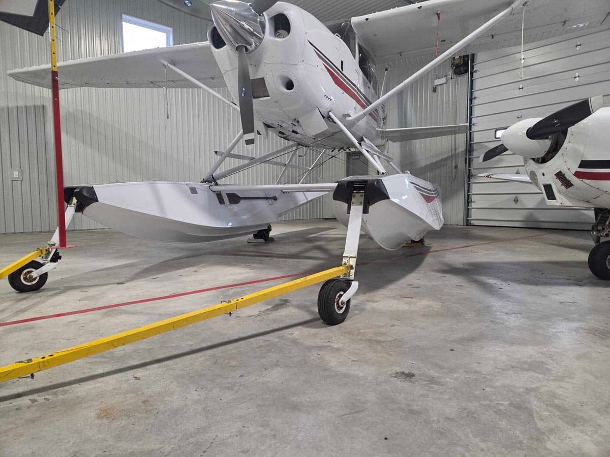Front view of a Cessna Caravan floatplane in a hangar.