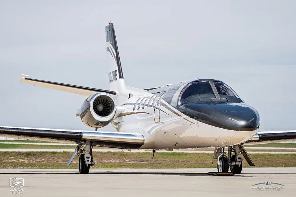 A front view of a white and dark grey Cessna Citation V (N550RB) business jet parked on an airport tarmac.