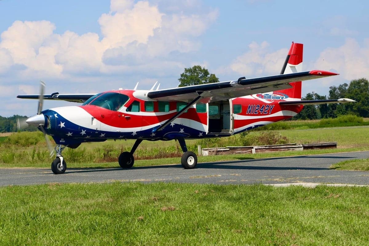 Side view of a red, white, and blue painted N1242Y aircraft on the ground.
