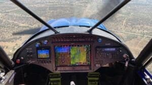 View of the instrument panel and forward view from the cockpit of an aircraft in flight.