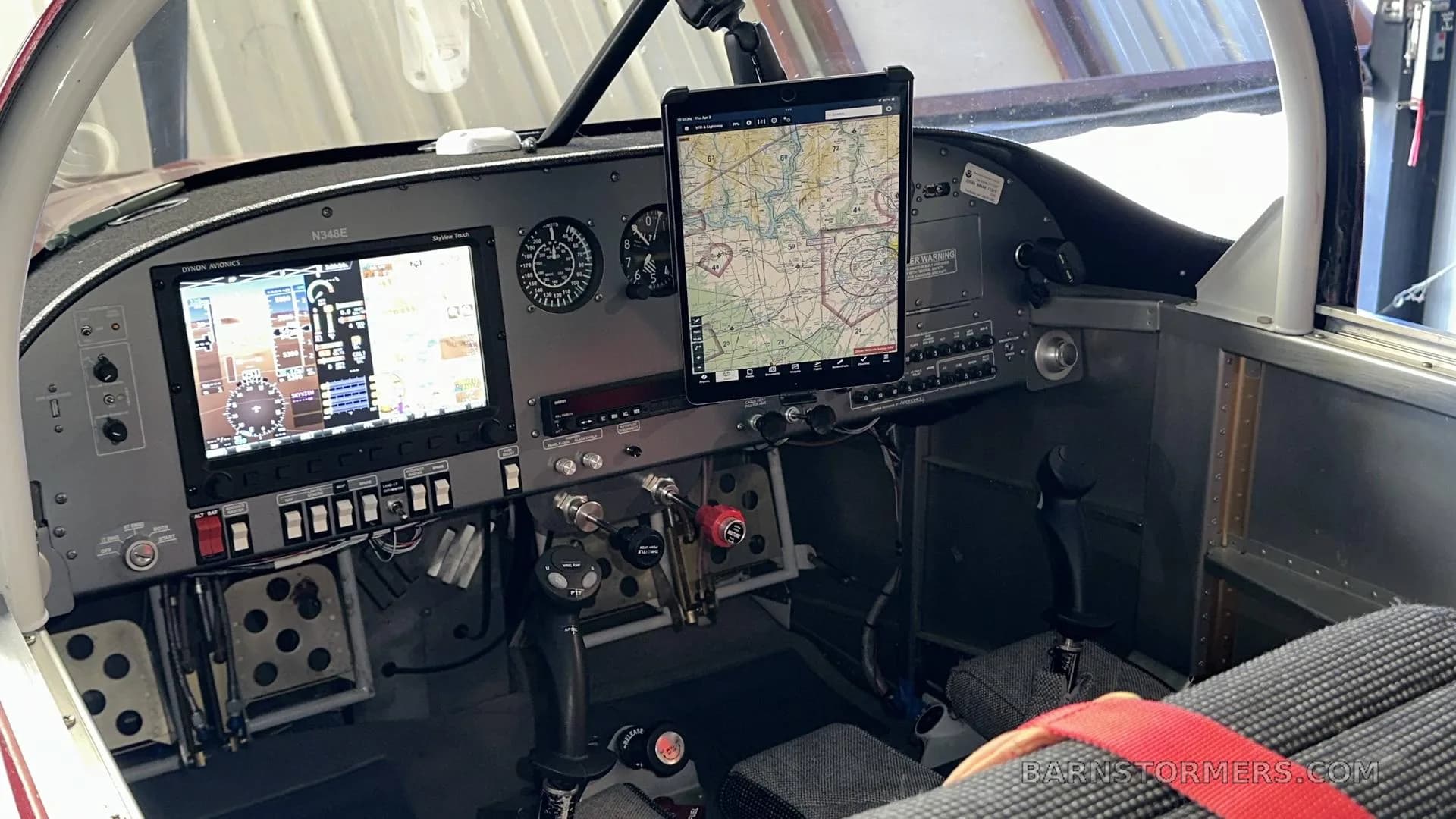 The cockpit of a small aircraft features a glass panel display, traditional gauges, and an iPad mounted on the dashboard.