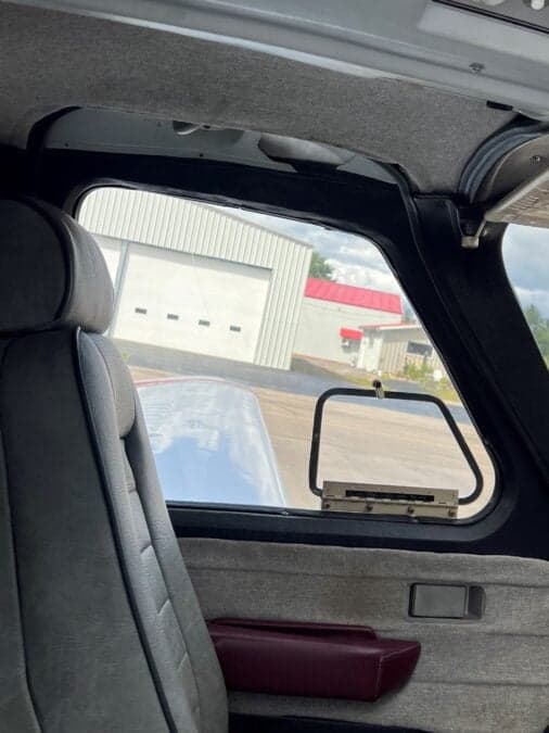 View from the rear seat looking out the window of the aircraft.