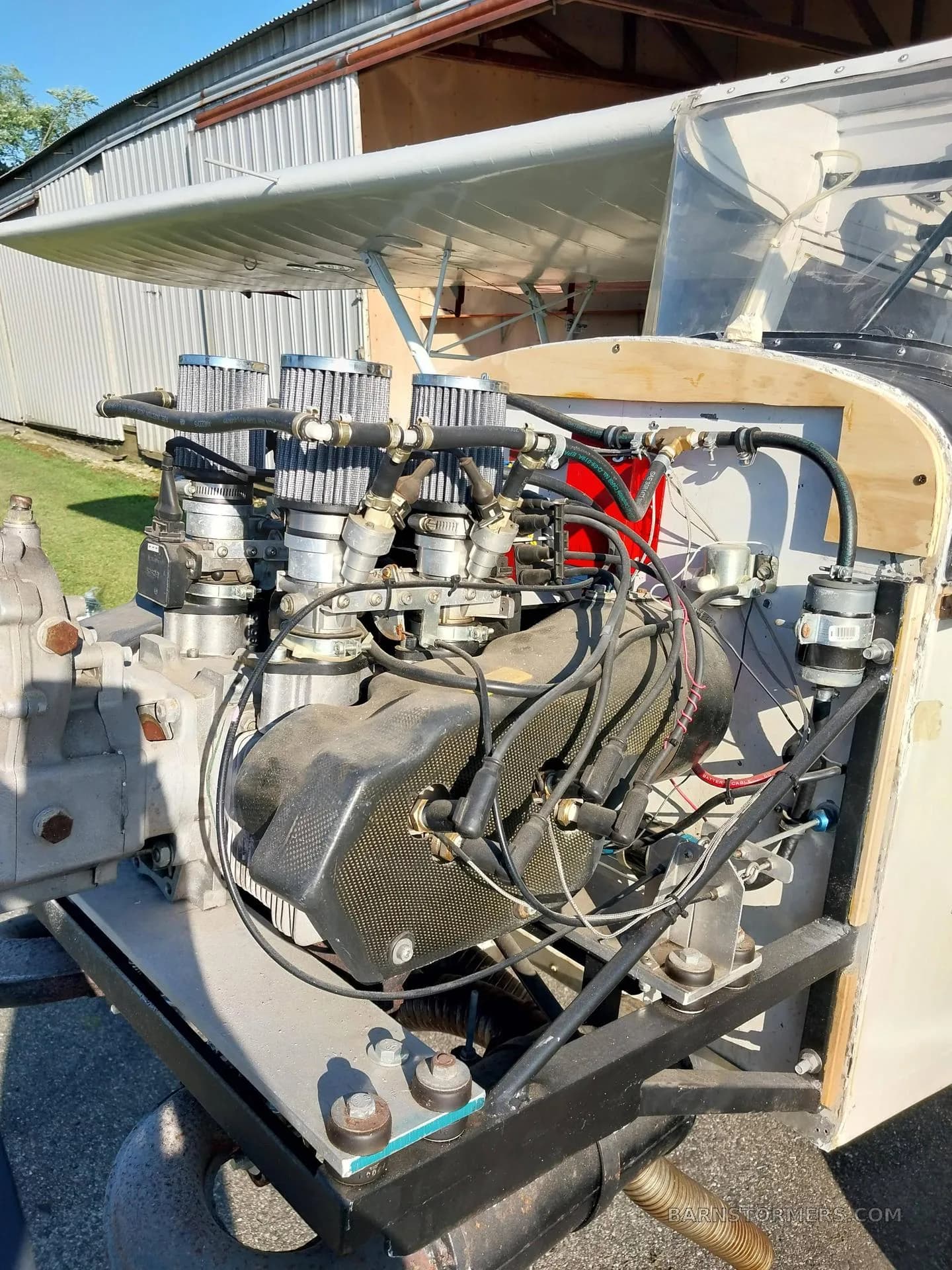 A detailed view of the exposed engine of an experimental aircraft, highlighting the air filters and engine components.