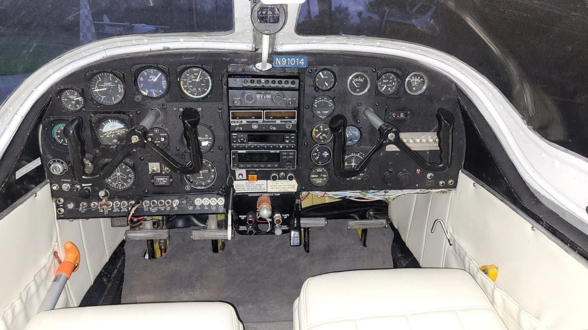 The cockpit of the aircraft features a full instrument panel and white seats.
