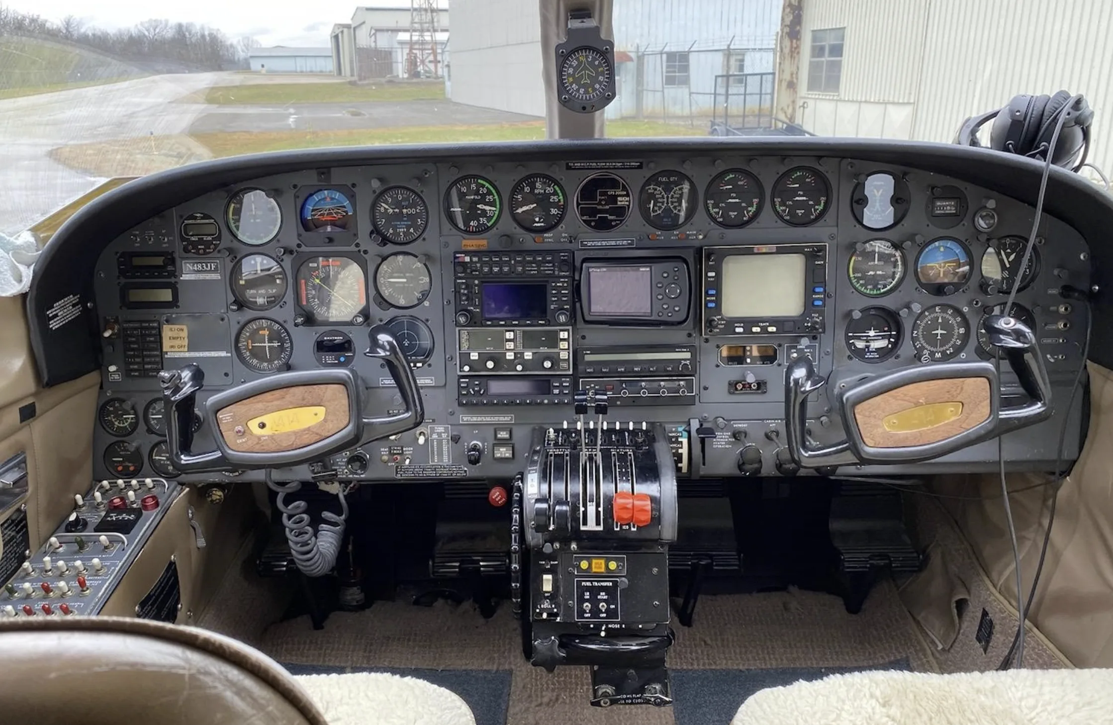 The cockpit features a complex instrument panel with analog gauges, multiple screens, and dual yokes, seen from the pilot's perspective.
