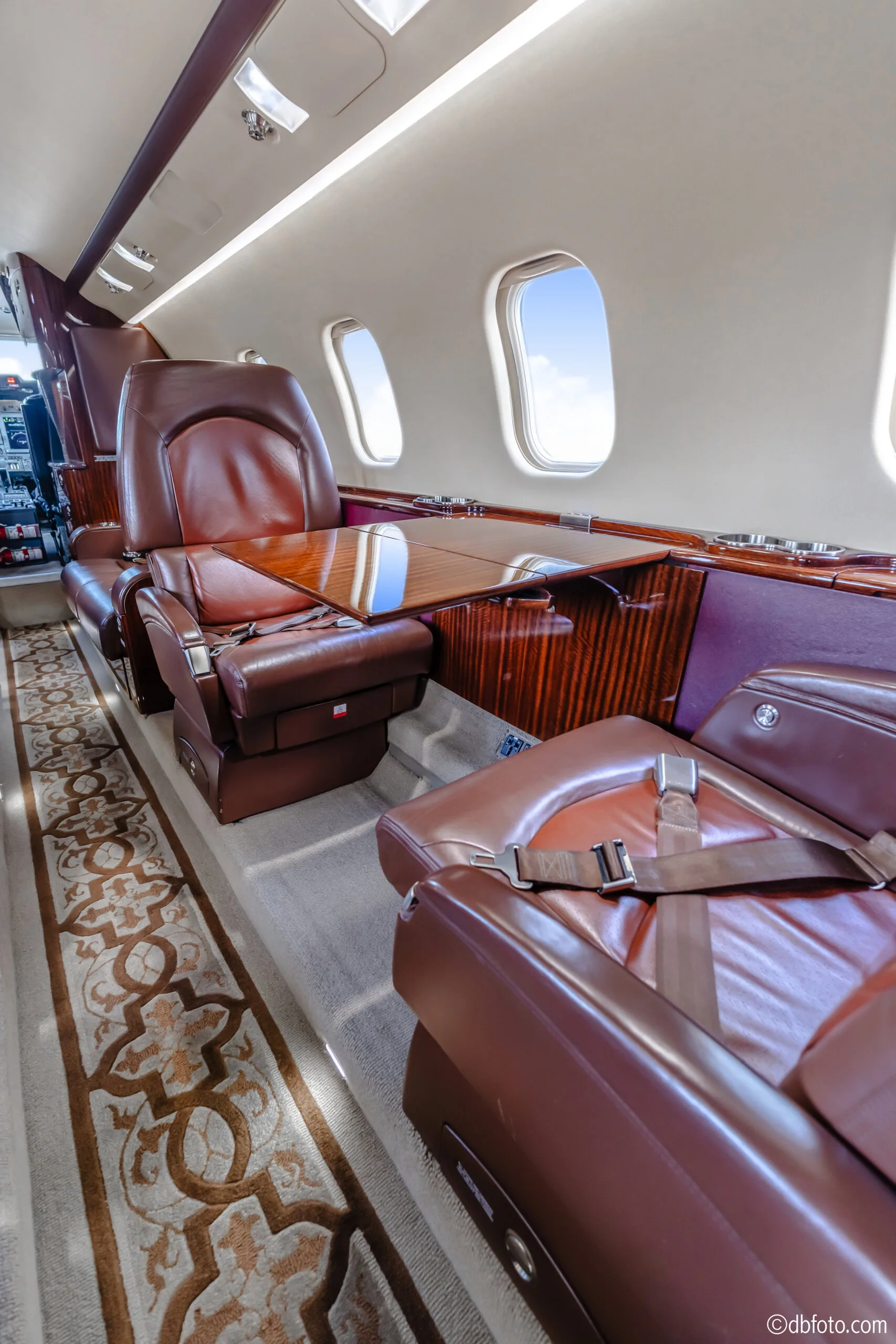 View of the Learjet 45XR cabin with leather seats and a table.