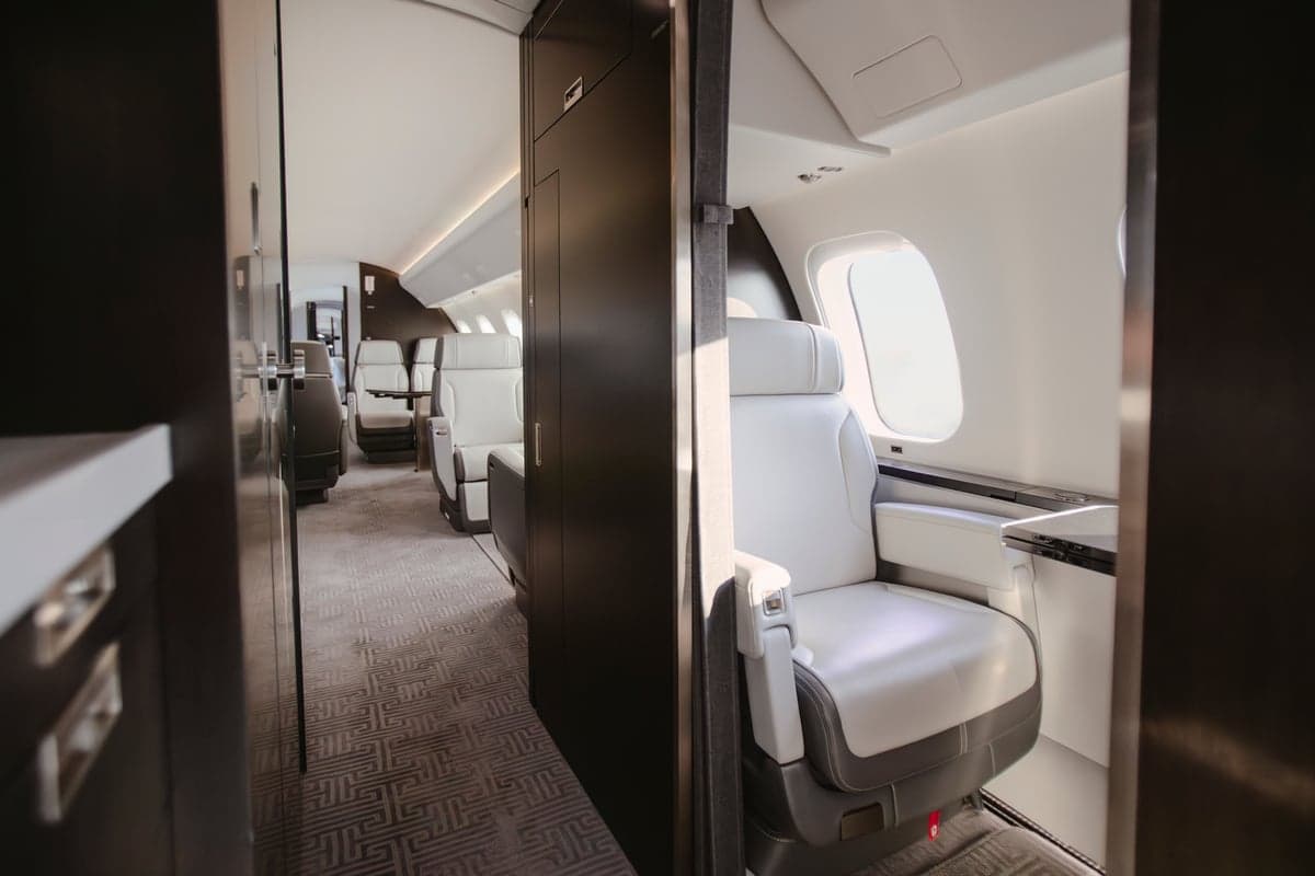 View of the aircraft interior with white leather seats and a table.