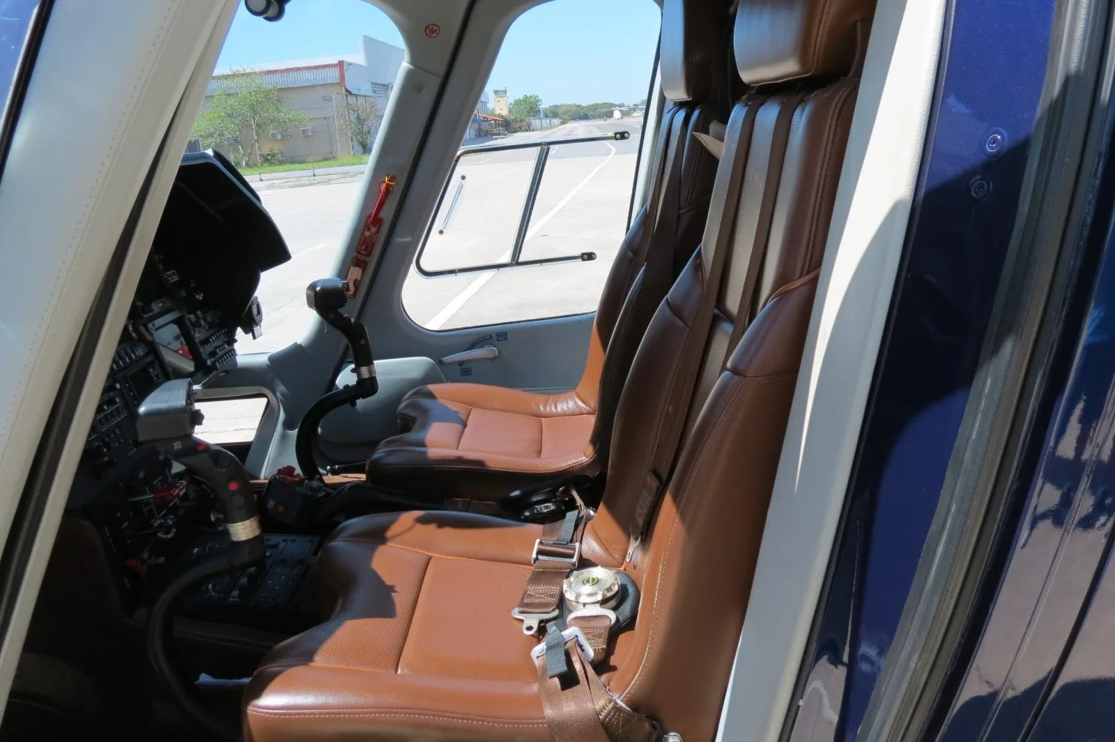 The interior of an AgustaWestland AW109 GrandNew helicopter, showing the seats and cockpit.