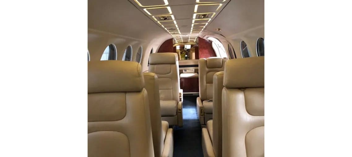 King Air cabin interior with tan leather seats and overhead lighting.