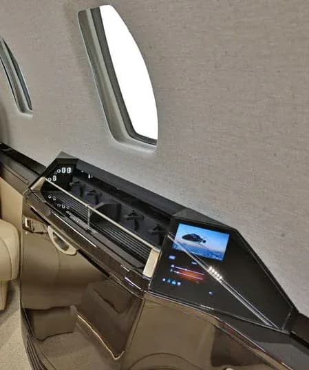 A close-up of an aircraft cabin control panel showing an image of a jet and environmental controls.