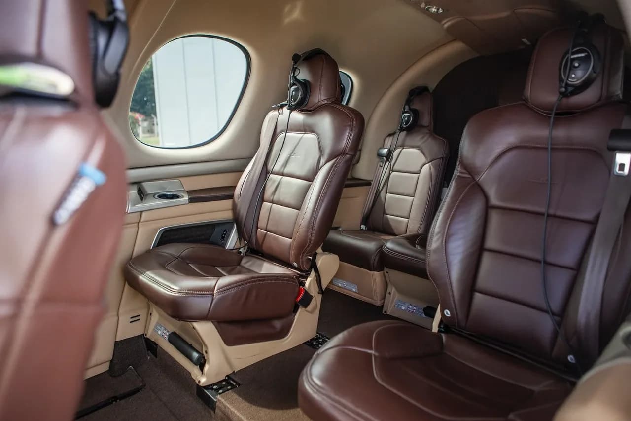 A view of the brown leather passenger seats and side panel in the cabin of a Cirrus Vision Jet.