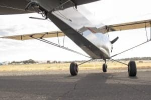 Low angle view of a gray and red Cubcrafters XCub on the tarmac.