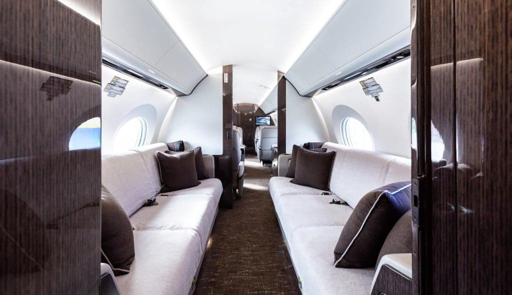 The aircraft's interior features leather seats and a table set for dining.