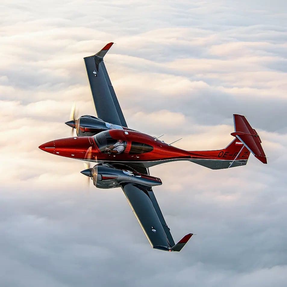 Diamond DA62 aircraft in flight over clouds.