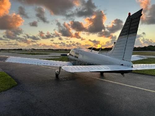 Rear view of Piper PA-28-181 Archer II aircraft N1435T parked on the tarmac at sunset.
