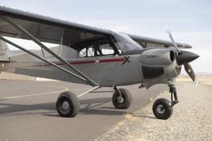 A gray and red Cubcrafters XCub on the tarmac.