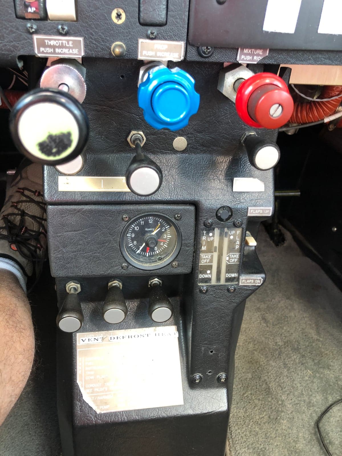 Close-up of the aircraft's throttle, mixture, and flap controls.