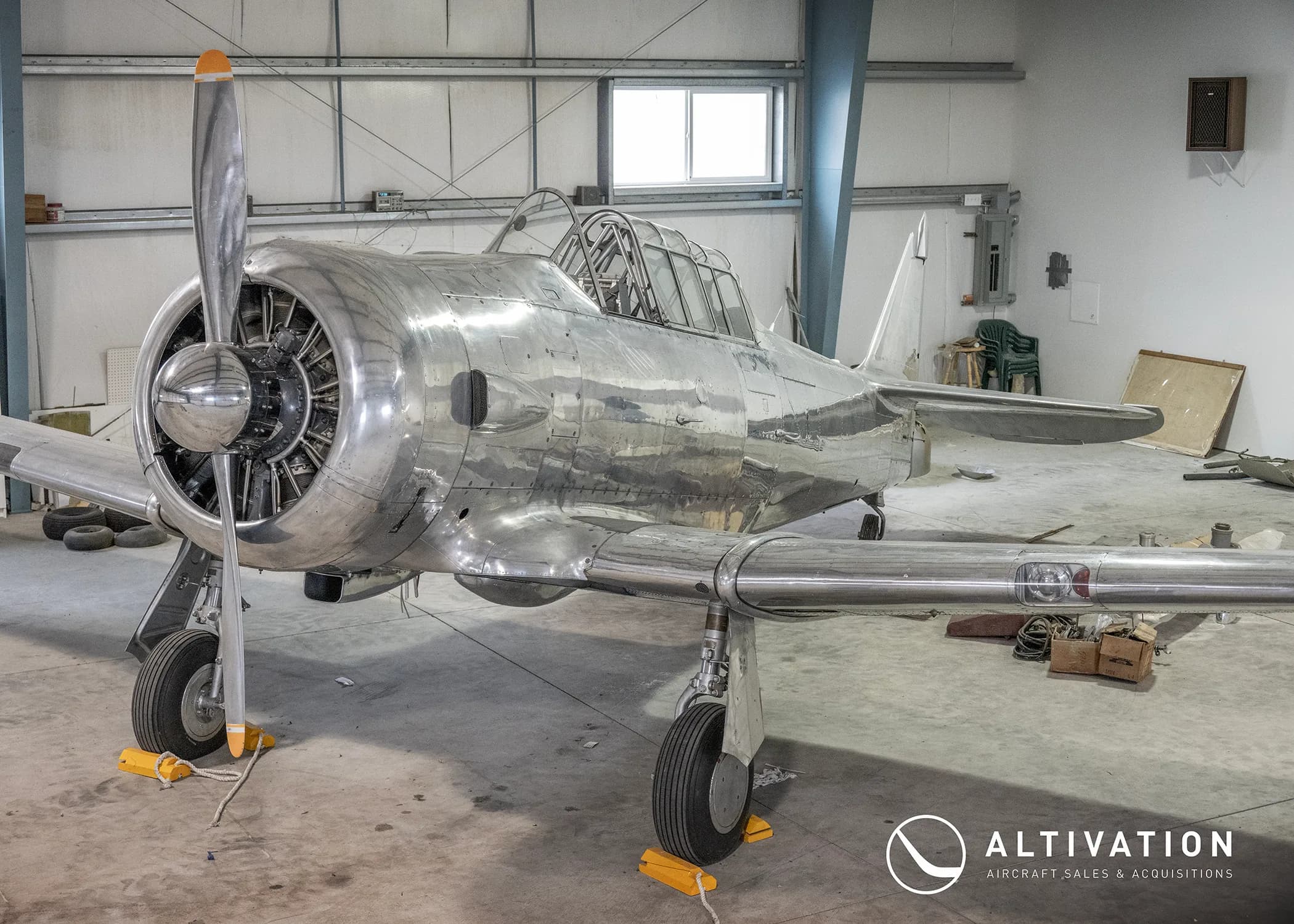 A silver aircraft in a hangar.