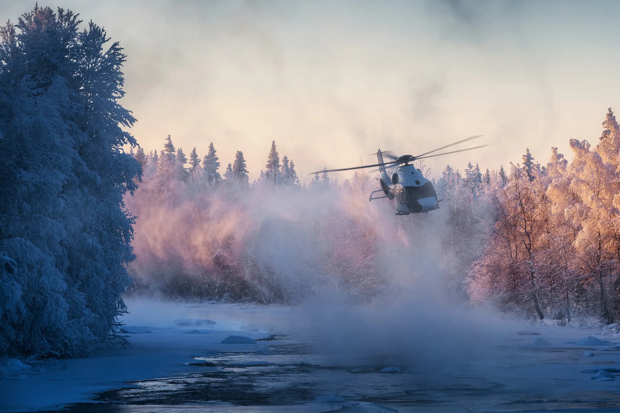 An Airbus H160 helicopter flying over a snowy landscape.