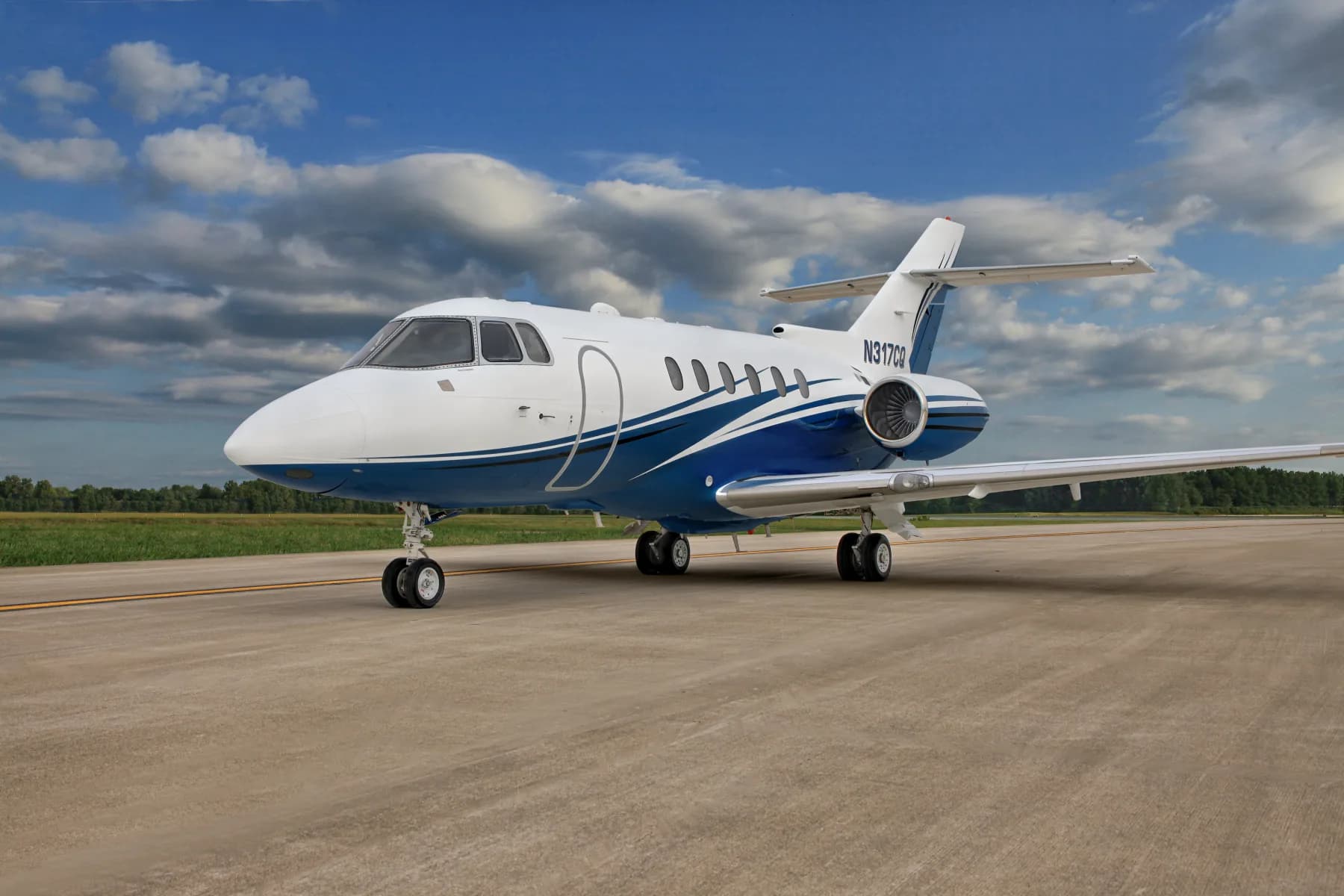 Front quarter view of the N317CQ aircraft on the tarmac with a blue and white paint scheme.