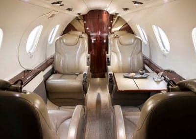 The Citation CJ3+ cabin features leather seats and a small table with refreshments.