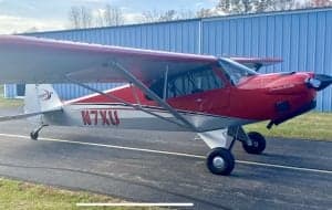Close-up of the red and silver Carbon Cub N7XU on the tarmac.