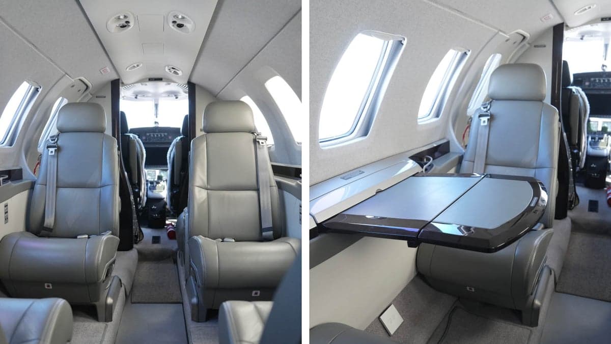 The aircraft's interior features gray leather seats and a fold-out table.