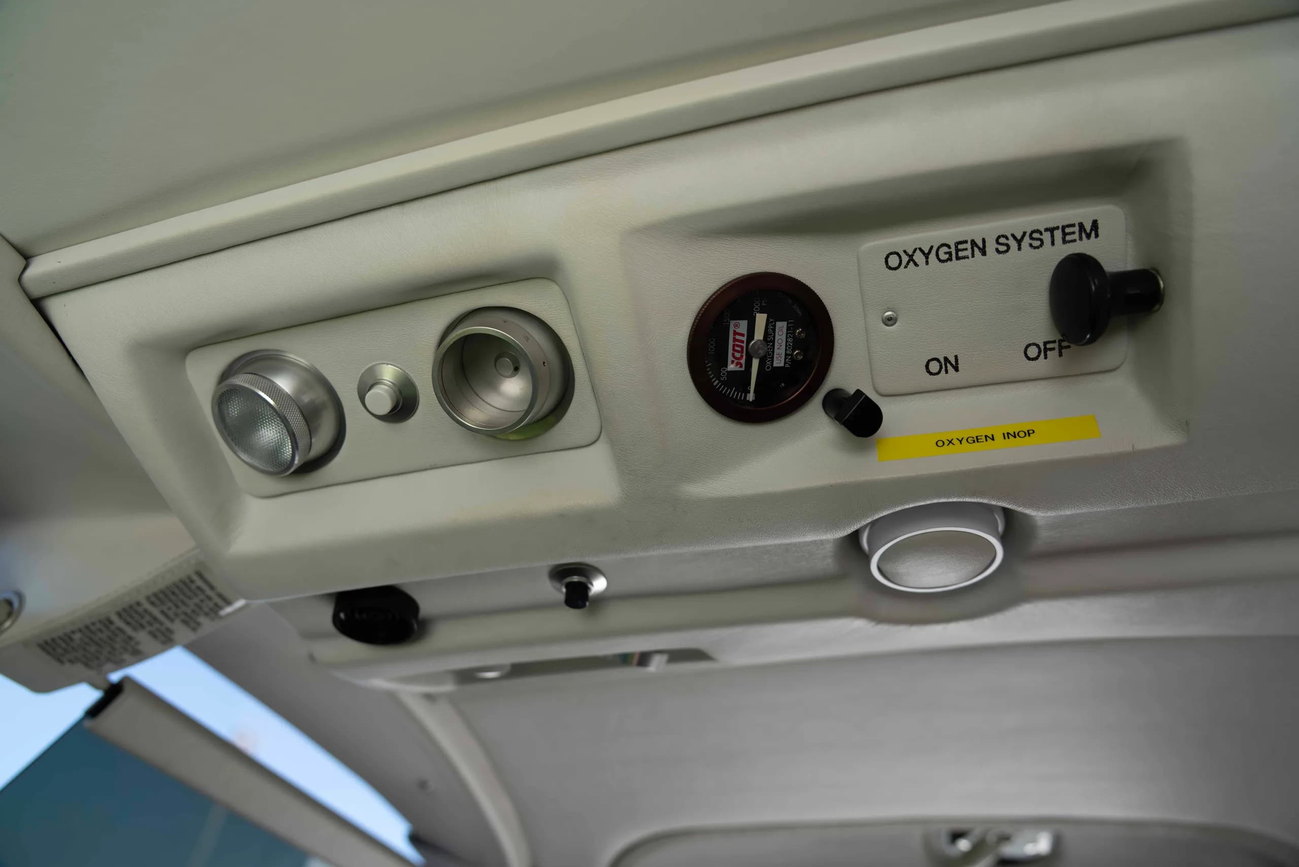 A close-up of the overhead oxygen system panel with controls and a pressure gauge.