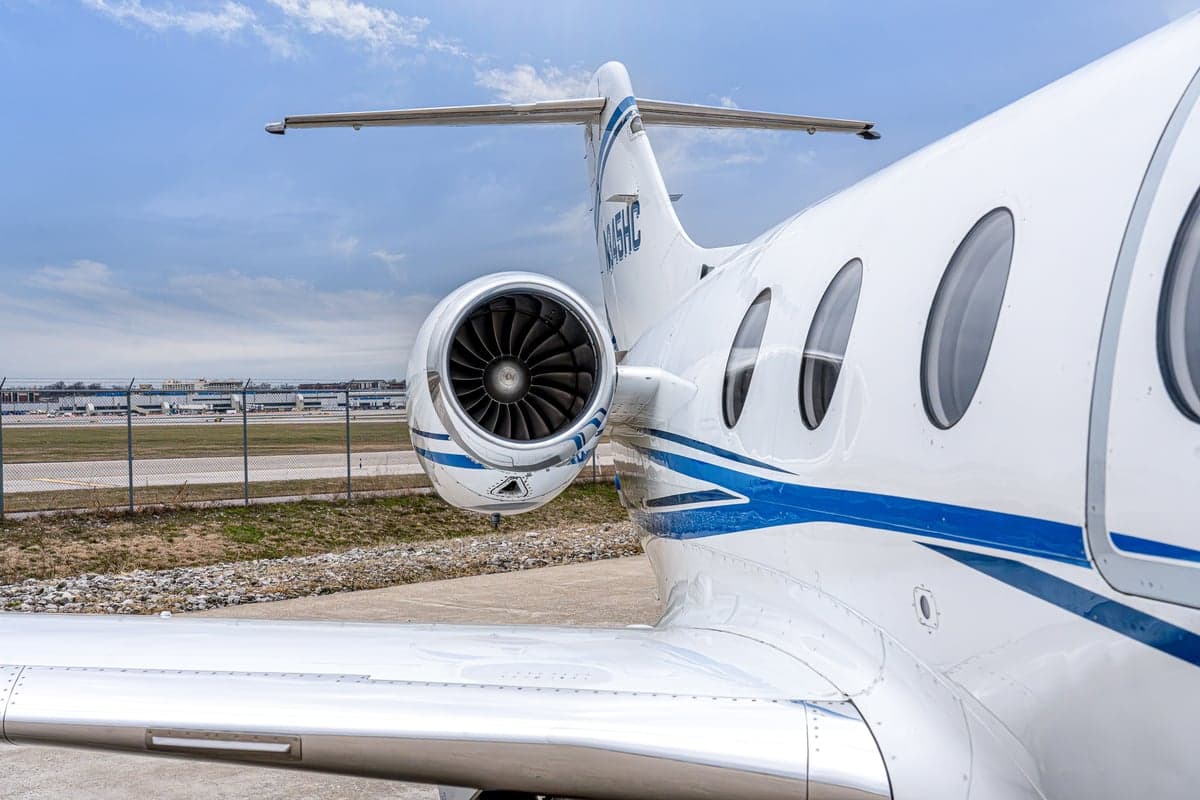 Rear view of a white aircraft with blue stripes, registration N45HC.