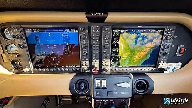 The cockpit of an aircraft featuring two large digital displays, one showing flight instruments and the other a geographical map.