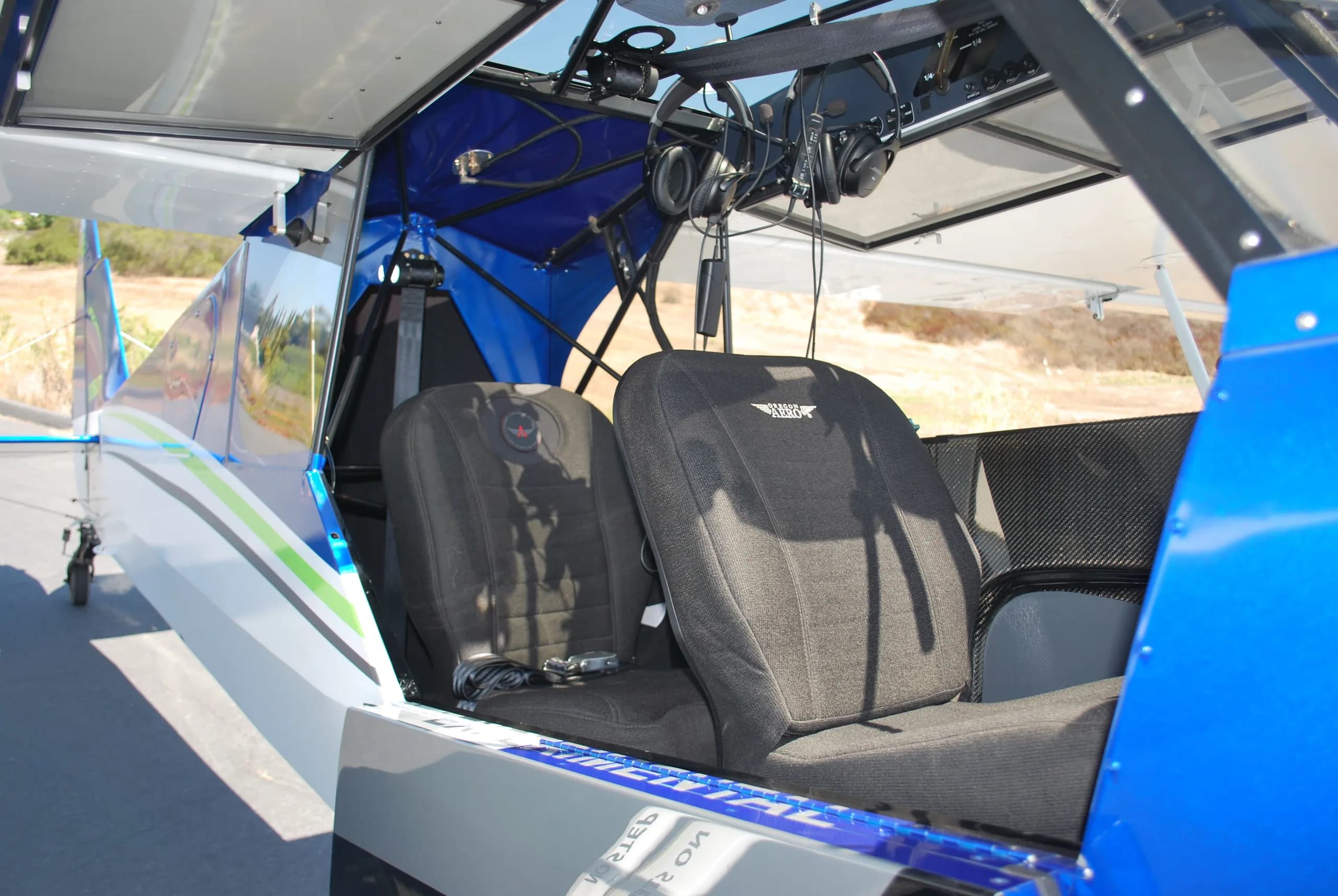 The two black fabric seats inside the cabin of a Carbon Cub FX3 aircraft.