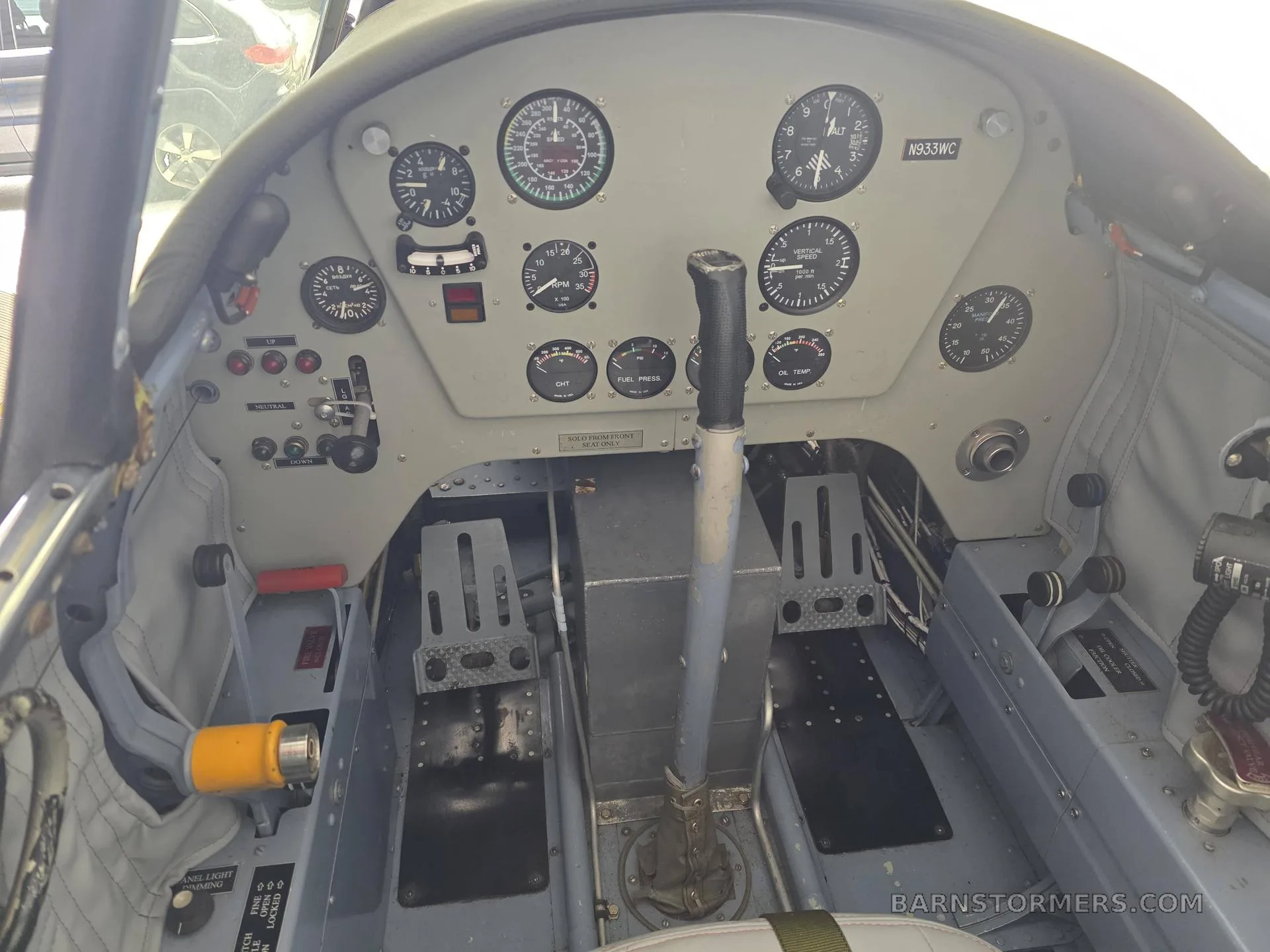 The rear cockpit of a Yakovlev Yak-52, featuring a simpler instrument panel with analog gauges and a control stick.