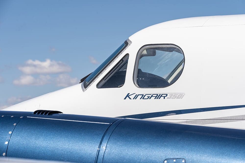 Close-up of the cockpit window and King Air 350i logo on the aircraft's nose.