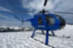 A blue helicopter parked on a tarmac.