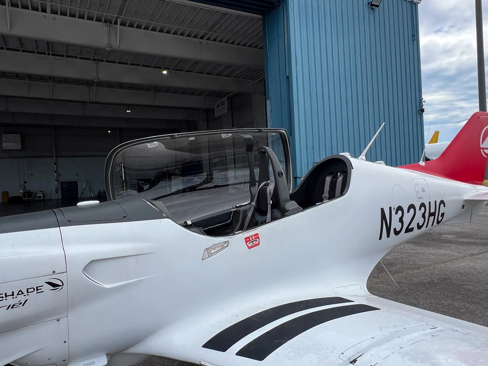 A Blackshape Gabriel aircraft with registration N323HG parked outside a hangar.