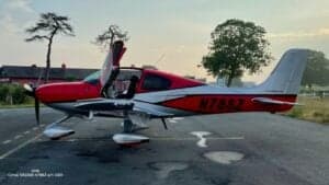 A Cirrus SR22G6 aircraft with registration N78SZ is parked on the tarmac with its doors open at dusk.