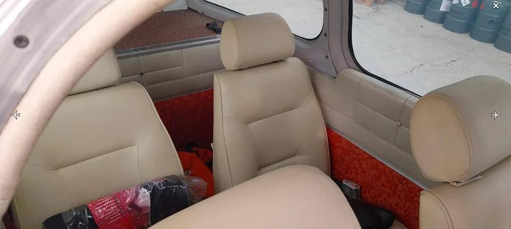 The light beige passenger seats in the aircraft's cabin, with orange patterned side panels.