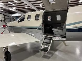 Side view of a turboprop aircraft with the door open.